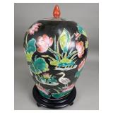 Asian porcelain ginger jar on a wood stand