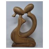 Carved wood sculpture depicting kissing couple