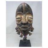 Vintage African carved wood mask adorned with
