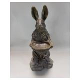 Composite sculpture of rabbit holding basket