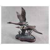 Vintage brass Canadian geese sculpture on a wood