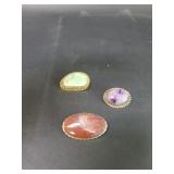 Amethyst, agate, and jadeite brooches set in