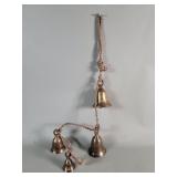 Vintage cluster of brass bells on a woven rope