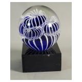 Hand blown glass paperweight on a glass base