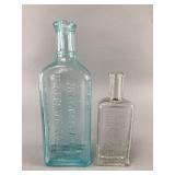 Two Embossed Glass Bottles
