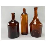 Three Embossed Amber Glass Bottles