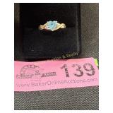 14 kt marked 2 tone bypass ring with lt blue stone