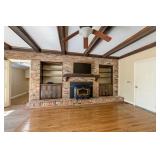 Den with wood burning insert in fireplace