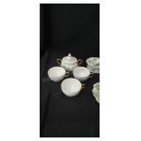 Assorted creamers, sugar bowls, tea cups, teabag
