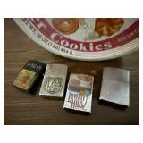 Cookie tin of Zippo, assorted lighters