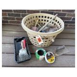 Basket of painting supplies, brushes, tape,
