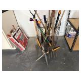Wire basket of yard tools, pruners, shovels, hay