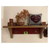 Shelf of knick knacks, pillow, blocks, statue,