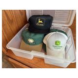 Storage tote of John Deere, assorted ball caps