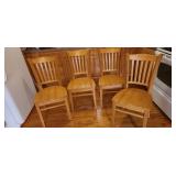 four wooden kitchen chairs