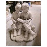 Decorative concrete couple reading lawn