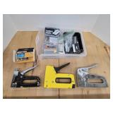 Three staple guns and assorted staples