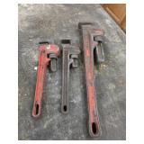 Three vintage pipe wrenches, two are rigid, one
