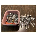 Various pink flatware in plastic tub