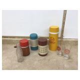 Collection of vintage thermoses and glass bottles including a Road Runner thermos