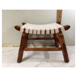 Old wooden footstool with white woven top