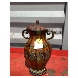 Ornate metal vase with handles and lid