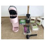 Pink Keurig coffee maker with filters and to-go cup