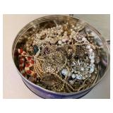 Collection of vintage jewelry in tin container