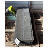 Bundle of black asphalt shingles, bldg:green