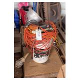 Extension cords, work light,  surge protector in a bucket bldg:green