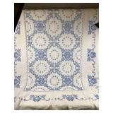 White Quilt With Blue Cross-Stitched Floral Design