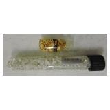 Glass vial of gold flakes and silver flakes