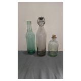 Three antique glass bottles one w wire stopper