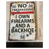 No trespassing I own firearms and a backhoe sign