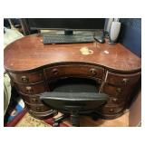 Kidney shaped vanity and black office chair.