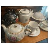 Tea cups and tea pots some have chips