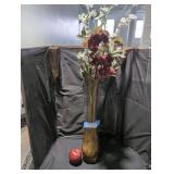 Tall amber glass vase with decorative flowers.
