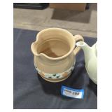 A ceramic pitcher and porcelain pitcher lot.