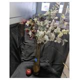 Tall amber glass vase with decorative flowers.