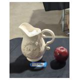 Ceramic pitcher with deer design.
