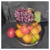Glass jar with metal handle and fake fruit inside.