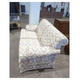 Traditional styled upholstered loveseat.