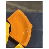 4 orange and yellow ceramic food trays.