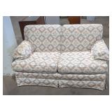 Traditional styled upholstered loveseat.