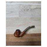 Carved hand holding pipe bowl with black stem