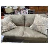 Brown folding sofa bed with 2 large throw pillows