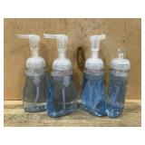 Four Clear Pump Bottles With Blue Liquid