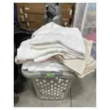 Laundry hamper full of white towels/ bath mats,