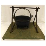 Cast iron 3 footed cauldron w/ stand on platform,