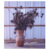 Peacock feathers in rattan urn vase